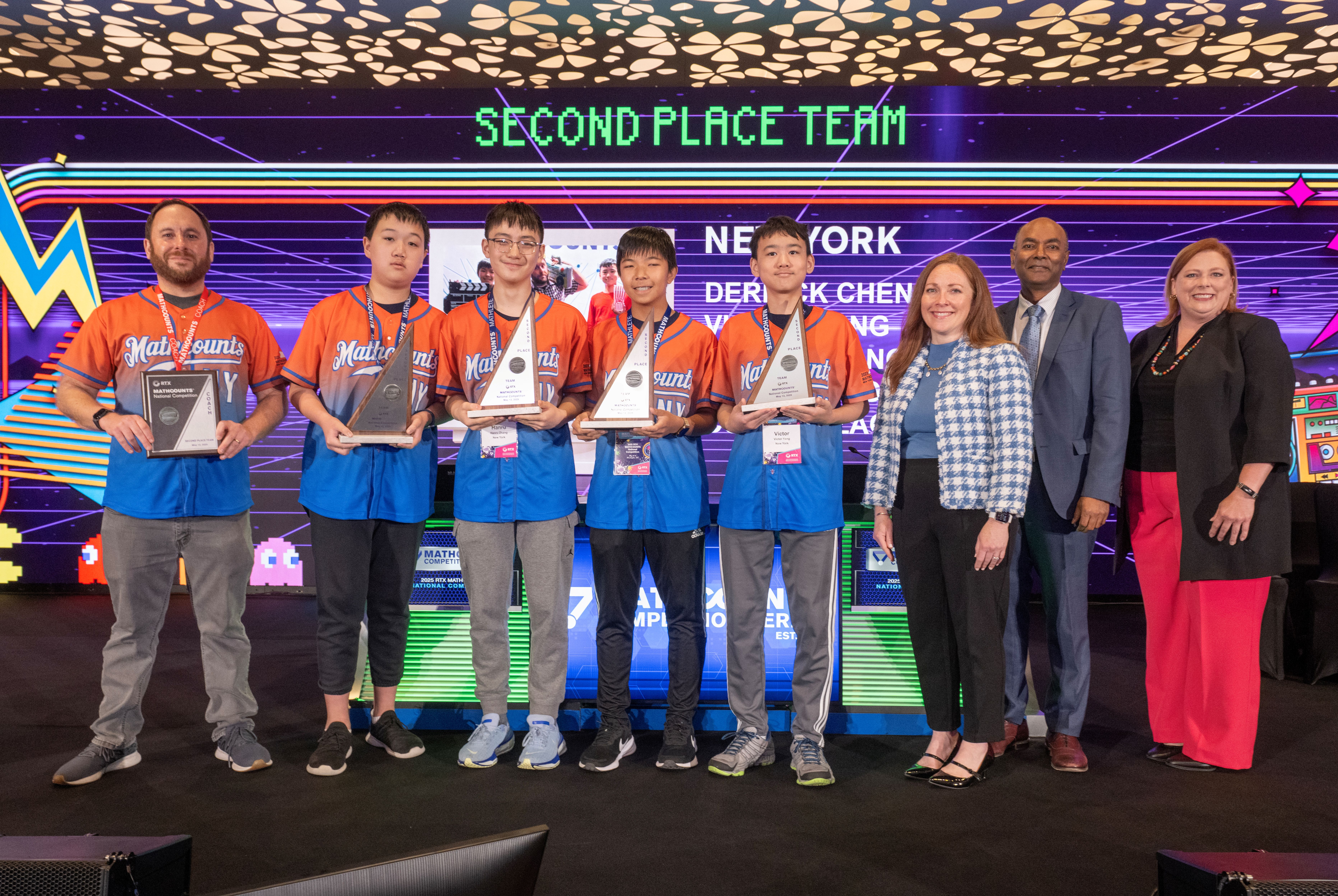 New York team poses with trophies and representatives from MATHCOUNTS, RTX and DoD STEM.
