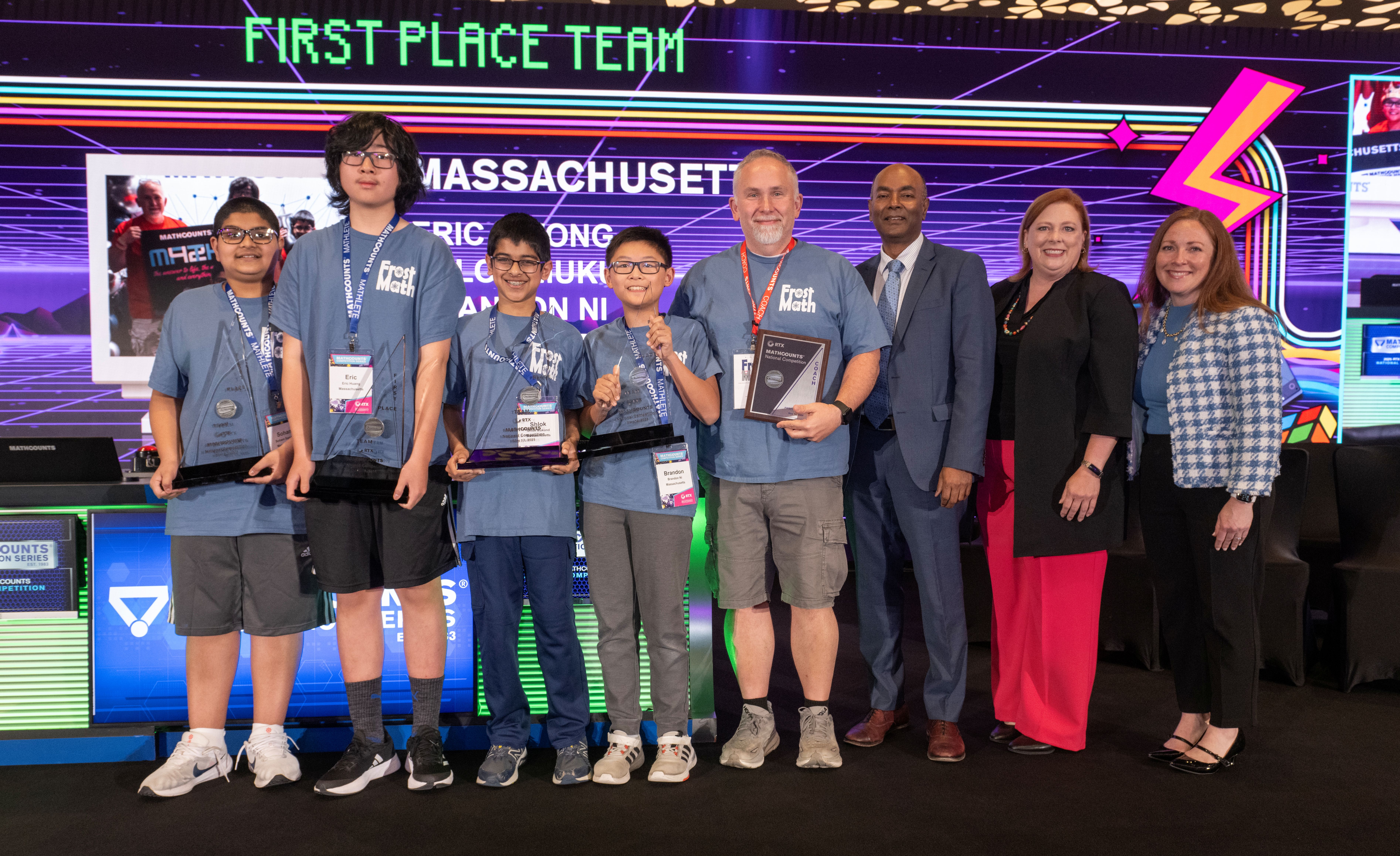 Massachusetts team smiles with trophies alongside representatives from MATHCOUNTS, RTX and DoD STEM