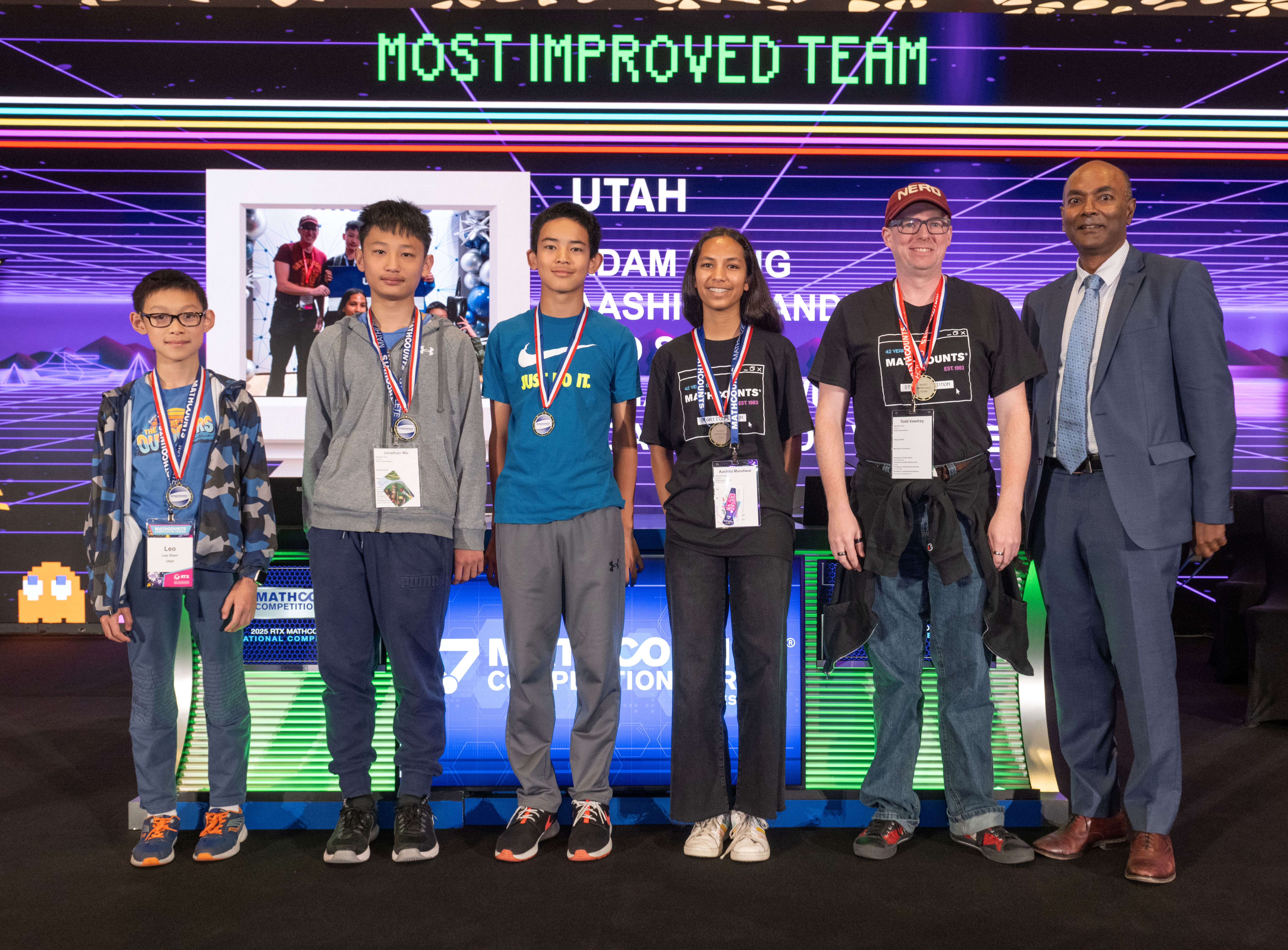 Team onstage with medals