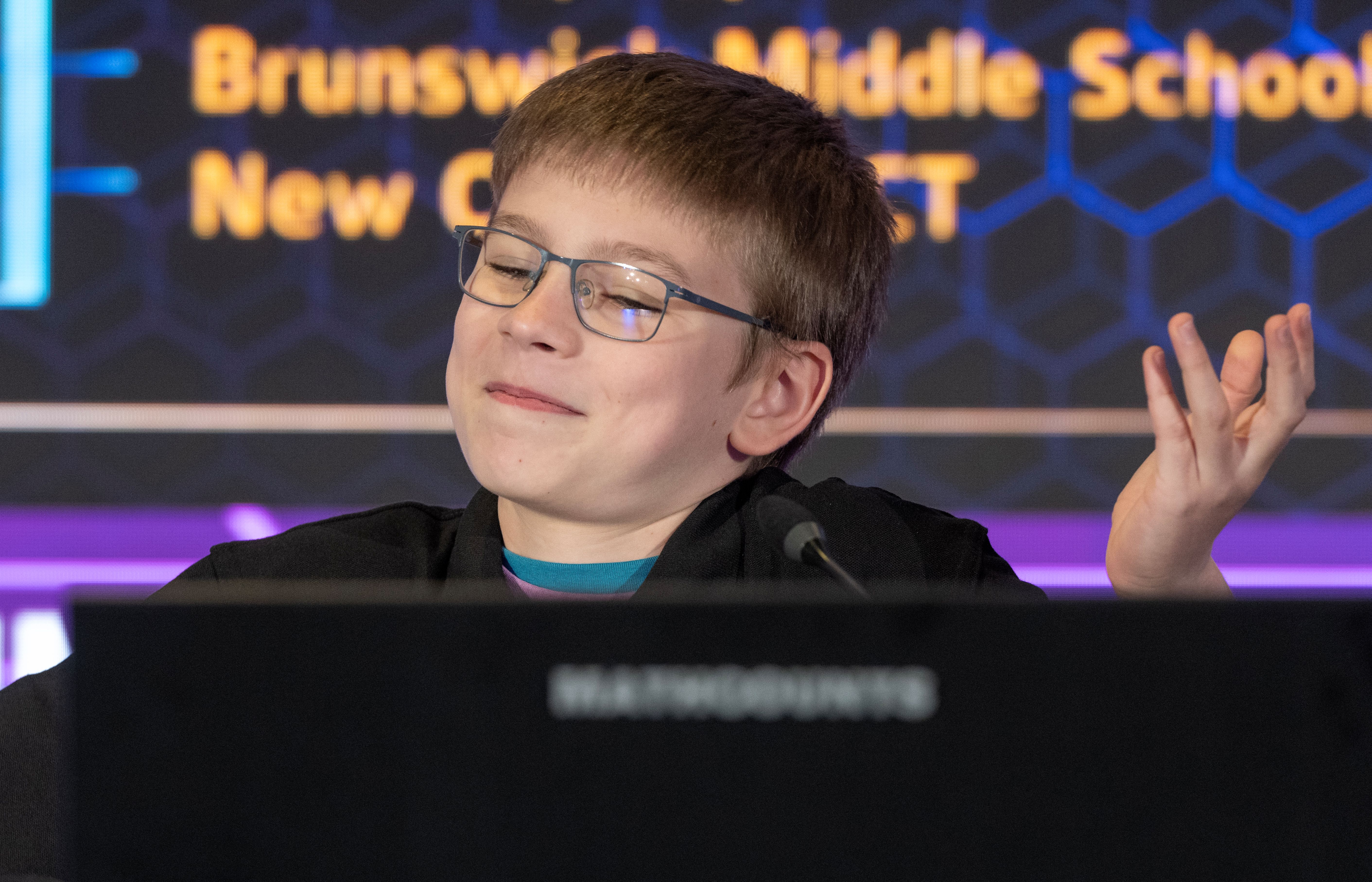 Alexander smiling and shrugging while onstage during the Countdown Round