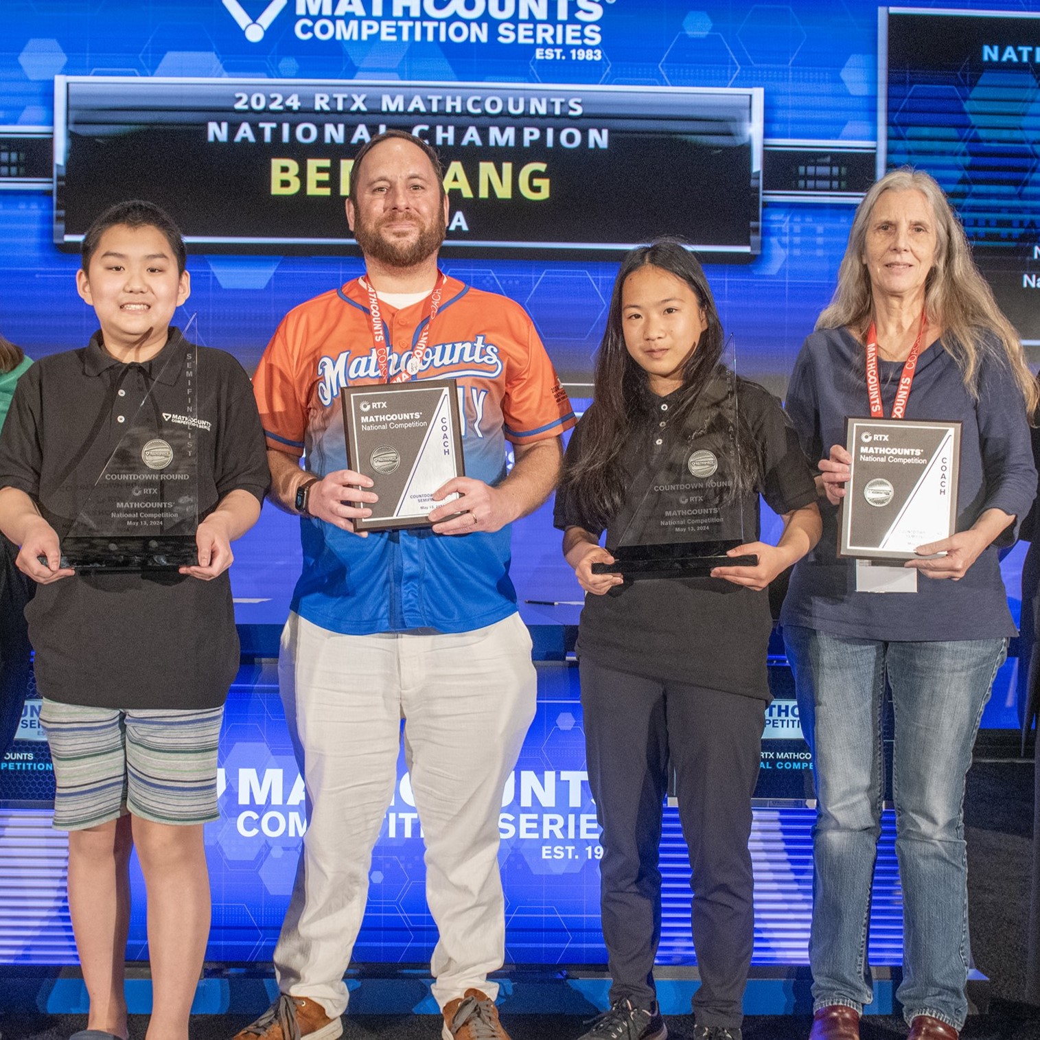 Semifinalists holding their trophies with their coaches